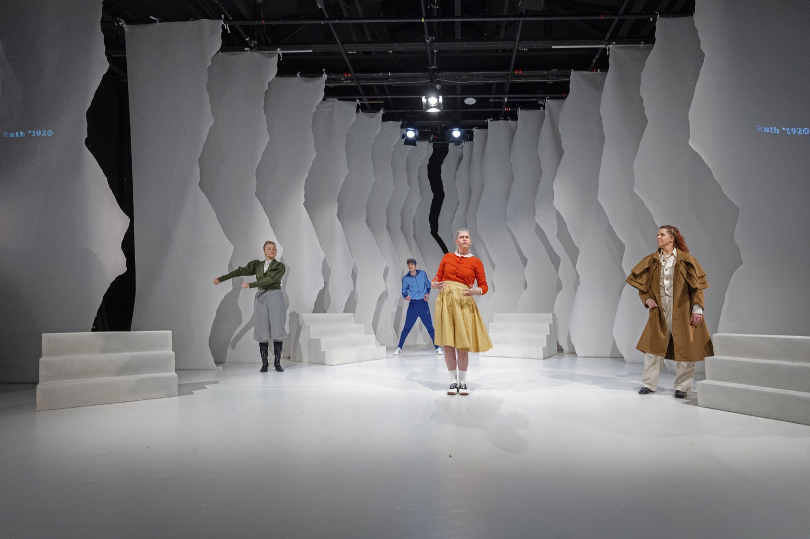 Gebärden der Geschichte mit Ensemble auf der hellen Bühne